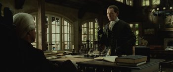 Movie still from “Pirates of the Caribbean: Dead Man's Chest” (2006), directed by Gore Verbinski – A man in a suit and tie holding a pen; Medium shot, Low angle
