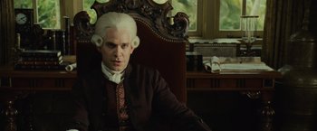 Movie still from “Pirates of the Caribbean: Dead Man's Chest” (2006), directed by Gore Verbinski – A man with white hair sitting in a chair; Medium shot, Low angle