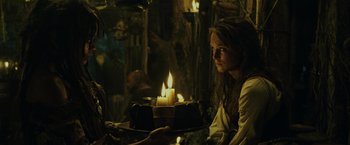 Movie still from “Pirates of the Caribbean: Dead Man's Chest” (2006), directed by Gore Verbinski – A woman is holding a tray with candles in it; Medium shot, Over the shoulder angle