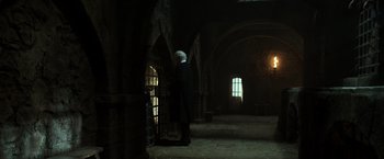 Movie still from “Pirates of the Caribbean: Dead Men Tell No Tales” (2017), directed by Espen Sandberg – An old man standing in a dark room looking out of a window; Wide shot, Low angle