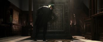 Movie still from “Pirates of the Caribbean: Dead Men Tell No Tales” (2017), directed by Espen Sandberg – A man wearing a green hat is looking at a wall; Wide shot, Low angle