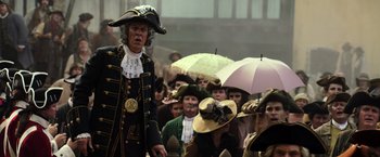 Movie still from “Pirates of the Caribbean: Dead Men Tell No Tales” (2017), directed by Espen Sandberg – A crowd of people in costumes with umbrellas; Medium shot, Over the shoulder angle