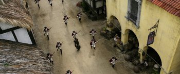 Movie still from “Pirates of the Caribbean: Dead Men Tell No Tales” (2017), directed by Espen Sandberg – A group of people dressed in period costumes are marching down a street; Extreme Wide shot, High angle