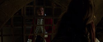 Movie still from “Pirates of the Caribbean: Dead Men Tell No Tales” (2017), directed by Espen Sandberg – A man in a red and white coat standing in front of a metal gate; Medium shot, Over the shoulder angle