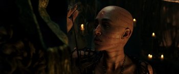 Movie still from “Pirates of the Caribbean: Dead Men Tell No Tales” (2017), directed by Espen Sandberg – A man with a tattoo on his face is looking at a candle; Close Up shot, Over the shoulder angle