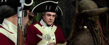 Movie still from “Pirates of the Caribbean: Dead Men Tell No Tales” (2017), directed by Espen Sandberg – A man in a red and white uniform holding a sword; Close Up shot, Over the shoulder angle