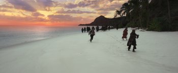 Movie still from “Pirates of the Caribbean: Dead Men Tell No Tales” (2017), directed by Espen Sandberg – A group of people walking along a beach at sunset; Extreme Wide shot, High angle