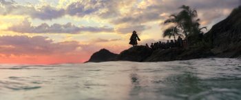 Movie still from “Pirates of the Caribbean: Dead Men Tell No Tales” (2017), directed by Espen Sandberg – A group of people sitting on top of a rock near the ocean; Extreme Wide shot, Low angle
