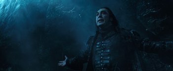 Movie still from “Pirates of the Caribbean: Dead Men Tell No Tales” (2017), directed by Espen Sandberg – A man with long black hair is standing in the dark; Medium shot, Low angle