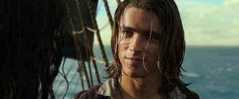 Movie still from “Pirates of the Caribbean: Dead Men Tell No Tales” (2017), directed by Espen Sandberg – A young man with long hair is standing on a boat; Close Up shot, Over the shoulder angle