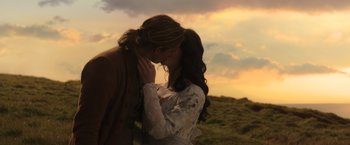Movie still from “Pirates of the Caribbean: Dead Men Tell No Tales” (2017), directed by Espen Sandberg – A man and a woman kissing in a grassy field; Medium shot, Low angle