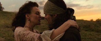 Movie still from “Pirates of the Caribbean: Dead Men Tell No Tales” (2017), directed by Espen Sandberg – A man and a woman are holding each other in a field; Close Up shot, Over the shoulder angle