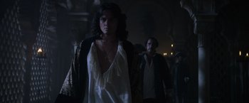 Movie still from “Pirates of the Caribbean: On Stranger Tides” (2011), directed by Rob Marshall – A woman standing next to a man in a dark room; Medium shot, Over the shoulder angle