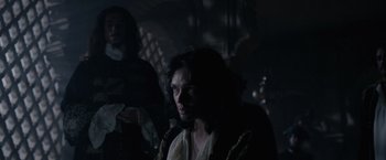 Movie still from “Pirates of the Caribbean: On Stranger Tides” (2011), directed by Rob Marshall – A man with long dark hair is in a dark room; Medium shot, Over the shoulder angle