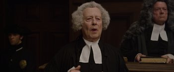 Movie still from “Pirates of the Caribbean: On Stranger Tides” (2011), directed by Rob Marshall – An old man dressed as a judge in a court room; Close Up shot, Over the shoulder angle