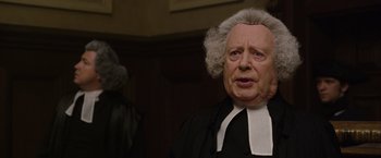 Movie still from “Pirates of the Caribbean: On Stranger Tides” (2011), directed by Rob Marshall – An old man dressed as a judge in front of a judge; Close Up shot, Over the shoulder angle