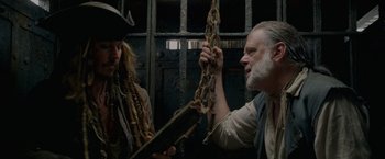 Movie still from “Pirates of the Caribbean: On Stranger Tides” (2011), directed by Rob Marshall – A man and a woman holding chains in a jail cell; Close Up shot, Low angle