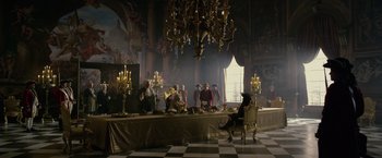 Movie still from “Pirates of the Caribbean: On Stranger Tides” (2011), directed by Rob Marshall – A group of people standing around a table; Wide shot, High angle