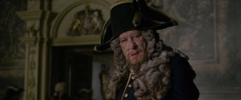 Movie still from “Pirates of the Caribbean: On Stranger Tides” (2011), directed by Rob Marshall – An old man in a wig and a hat; Close Up shot, Over the shoulder angle