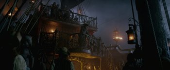 Movie still from “Pirates of the Caribbean: On Stranger Tides” (2011), directed by Rob Marshall – A man standing on the balcony of a pirate ship at night; Wide shot, Low angle