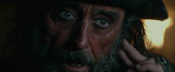 Movie still from “Pirates of the Caribbean: On Stranger Tides” (2011), directed by Rob Marshall – An old man with a beard and a hat is looking at the camera; Extreme Close Up shot, Overhead angle