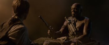 Movie still from “Pirates of the Caribbean: On Stranger Tides” (2011), directed by Rob Marshall – An image of a person holding a gun in a dark room; Medium shot, Low angle