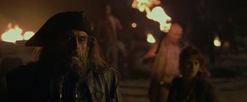 Movie still from “Pirates of the Caribbean: On Stranger Tides” (2011), directed by Rob Marshall – A man with long hair and a beard wearing a hat; Close Up shot, Over the shoulder angle
