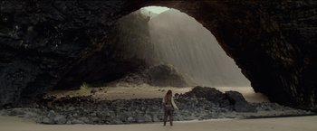 Movie still from “Pirates of the Caribbean: On Stranger Tides” (2011), directed by Rob Marshall – A woman standing in front of a cave on the beach; Extreme Wide shot, Low angle