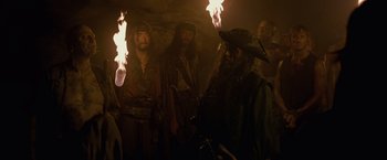 Movie still from “Pirates of the Caribbean: On Stranger Tides” (2011), directed by Rob Marshall – A group of men in pirate garb holding torches; Medium shot, Low angle