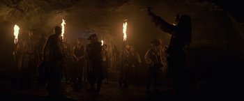 Movie still from “Pirates of the Caribbean: On Stranger Tides” (2011), directed by Rob Marshall – A group of people standing in a cave with a fire; Wide shot, Low angle