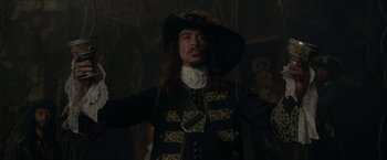 Movie still from “Pirates of the Caribbean: On Stranger Tides” (2011), directed by Rob Marshall – A man in a pirate costume is standing in a dark room; Medium shot, Low angle