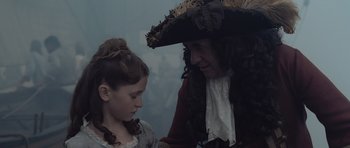 Movie still from “Pirates of the Caribbean: The Curse of the Black Pearl” (2003), directed by Gore Verbinski – A man and a young girl dressed in period clothing; Close Up shot, Over the shoulder angle