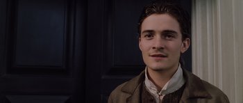 Movie still from “Pirates of the Caribbean: The Curse of the Black Pearl” (2003), directed by Gore Verbinski – A young man wearing a brown jacket and a white shirt; Close Up shot, Low angle