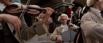 Movie still from “Pirates of the Caribbean: The Curse of the Black Pearl” (2003), directed by Gore Verbinski – A man playing a cello in front of another man playing a violin; Medium shot, Low angle
