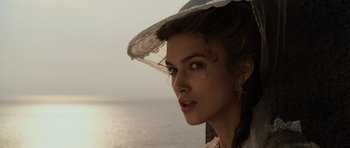 Movie still from “Pirates of the Caribbean: The Curse of the Black Pearl” (2003), directed by Gore Verbinski – A beautiful woman with a lace hat looking into the distance; Close Up shot, Over the shoulder angle