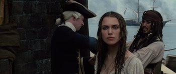 Movie still from “Pirates of the Caribbean: The Curse of the Black Pearl” (2003), directed by Gore Verbinski – A man in a pirate hat is fixing a woman's hair; Close Up shot, Over the shoulder angle