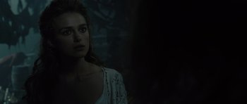 Movie still from “Pirates of the Caribbean: The Curse of the Black Pearl” (2003), directed by Gore Verbinski – A woman is standing in a dark room; Close Up shot, Over the shoulder angle