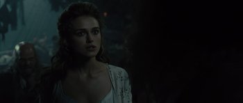 Movie still from “Pirates of the Caribbean: The Curse of the Black Pearl” (2003), directed by Gore Verbinski – A woman in a white shirt is standing in the dark; Close Up shot, Over the shoulder angle