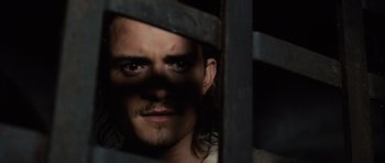 Movie still from “Pirates of the Caribbean: The Curse of the Black Pearl” (2003), directed by Gore Verbinski – A person looking through a fence; Close Up shot, Low angle