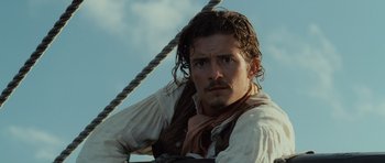 Movie still from “Pirates of the Caribbean: The Curse of the Black Pearl” (2003), directed by Gore Verbinski – A person on a boat with a sky background; Close Up shot, Low angle