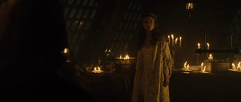 Movie still from “Pirates of the Caribbean: The Curse of the Black Pearl” (2003), directed by Gore Verbinski – A woman standing in front of candles in a dark room; Medium shot, Low angle