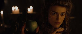Movie still from “Pirates of the Caribbean: The Curse of the Black Pearl” (2003), directed by Gore Verbinski – A woman holding an apple in front of a candle; Close Up shot, Over the shoulder angle