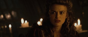 Movie still from “Pirates of the Caribbean: The Curse of the Black Pearl” (2003), directed by Gore Verbinski – A person with a candle in the background; Close Up shot, Over the shoulder angle