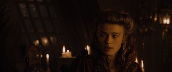 Movie still from “Pirates of the Caribbean: The Curse of the Black Pearl” (2003), directed by Gore Verbinski – A young woman in a dark room next to lit candles; Close Up shot, Over the shoulder angle