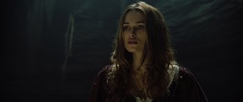 Movie still from “Pirates of the Caribbean: The Curse of the Black Pearl” (2003), directed by Gore Verbinski – A woman with long brown hair wearing a purple dress; Close Up shot, Low angle