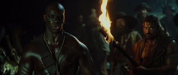 Movie still from “Pirates of the Caribbean: The Curse of the Black Pearl” (2003), directed by Gore Verbinski – A man is holding a torch in the dark; Close Up shot, Low angle