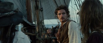 Movie still from “Pirates of the Caribbean: The Curse of the Black Pearl” (2003), directed by Gore Verbinski – A man with a beard standing next to a boat; Close Up shot, Over the shoulder angle