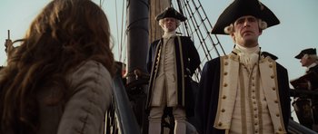 Movie still from “Pirates of the Caribbean: The Curse of the Black Pearl” (2003), directed by Gore Verbinski – A man in a uniform on a boat; Medium shot, Low angle