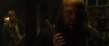 Movie still from “Pirates of the Caribbean: The Curse of the Black Pearl” (2003), directed by Gore Verbinski – A man with a beard holding an object in his hand; Close Up shot, Low angle