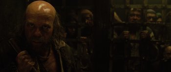 Movie still from “Pirates of the Caribbean: The Curse of the Black Pearl” (2003), directed by Gore Verbinski – A group of people standing next to each other in a room; Close Up shot, Over the shoulder angle